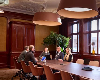 Three people sitting around a table.