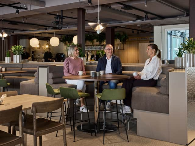 Three people sitting talking.